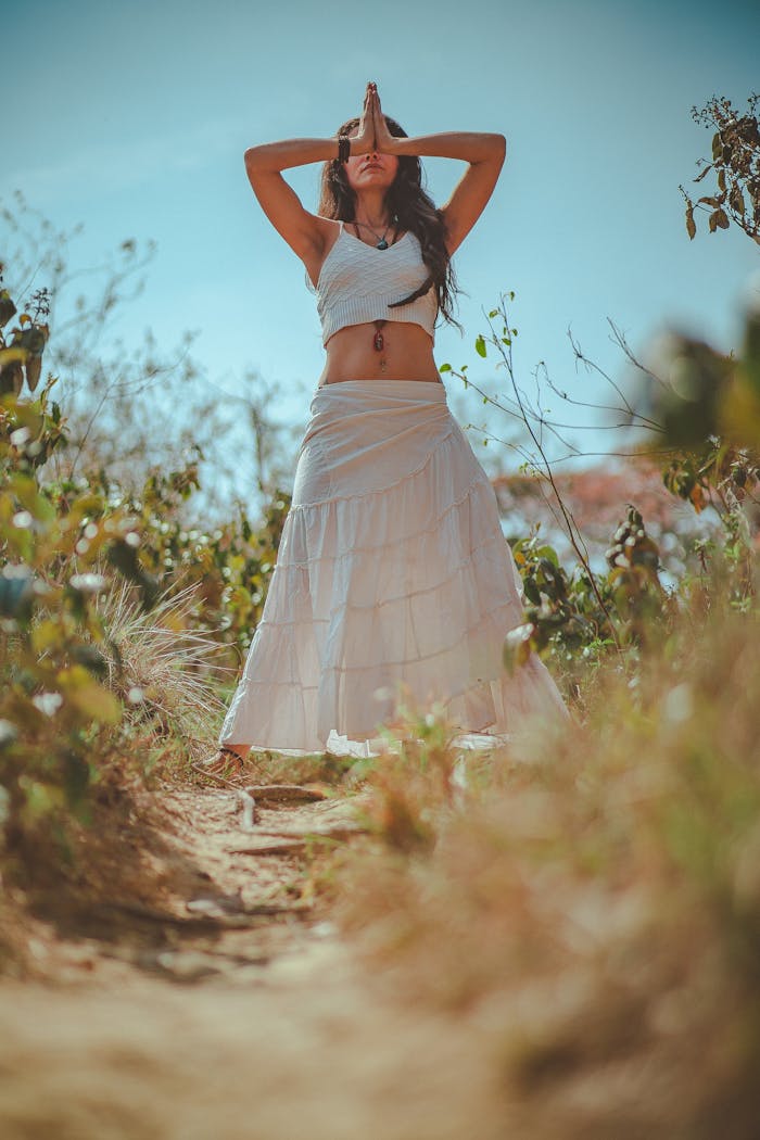 Crafting Captivating Headlines: Your awesome post title goes here Young woman meditating in a peaceful outdoor setting wearing a white skirt.